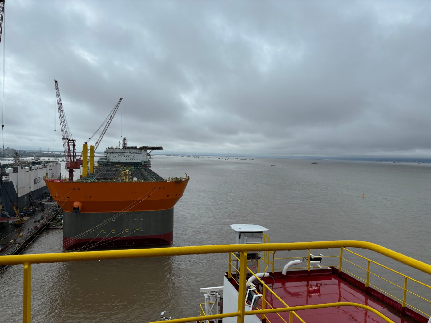 A vessel under construction alongside a shipyard quay